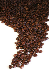 Coffee beans spilled onto a white surface.