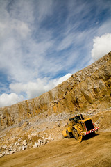 Bulldozer working in quarry - angled shot with blue sky