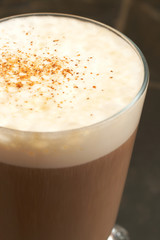 A cup of cafe latte with foam and cinnamon