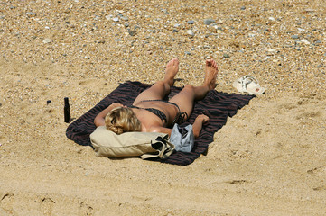 femme qui bronze sur la plage