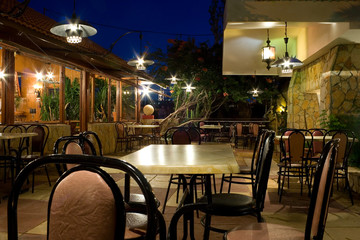 Tables and chairs in a greek restaurant at night
