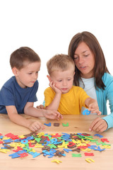 children and mother playing with letters isolated on white