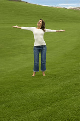 Happy Woman relaxing on a beautiful green meadow