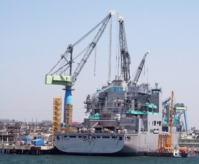 A military ship docked in the shipyard getting upgraded