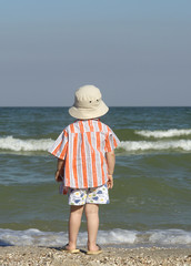a boy standing near the sea