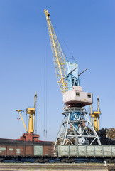 Fototapeta na wymiar The elevating crane costing on loading of cars on a railway way