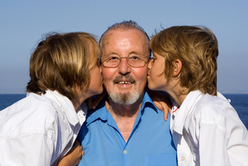  grandfather with loving grandchildren kising cheek