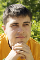 A young guy with dreamy eyes in the park