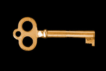 close-up of gold vintage key isolated on black background