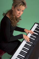 Young attractive Latina woman playing piano