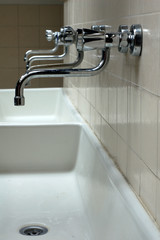 A row of faucets in a community laundry room.