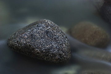 Long exposure of a rock sitting in a stream. 
