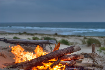 beach campfire at dusk and coastline view