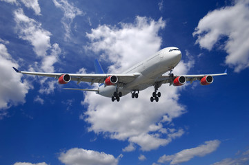 Plane going to land. Blue and cloudy sky.