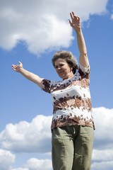 woman with smile on blue sky and clouds