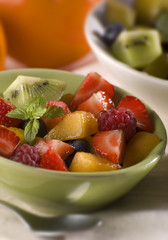 mixed fresh fruit in green bowl close up