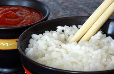 chinesse rice and hot spice sauce bowl with two chopsticks