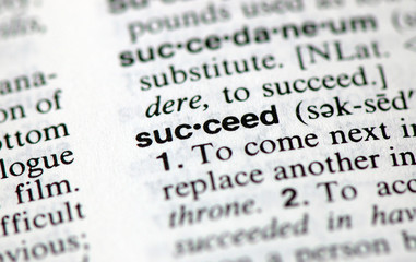 A macro shot of the word "Succeed" from the dictionary