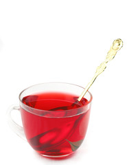 red tea in glass cup with golden spoon
