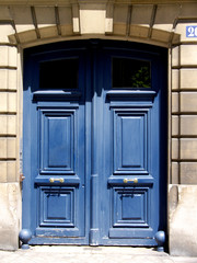 Porte cochère bleue sur  façade de pierre