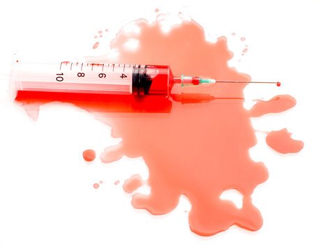 Syringe in a pool of blood on a white background