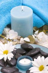 Massage stones, candle and daisies