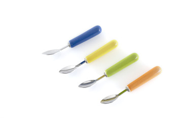 four modern colored spoons in a row
