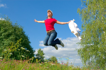 Beautiful lady jumping in summer landscape