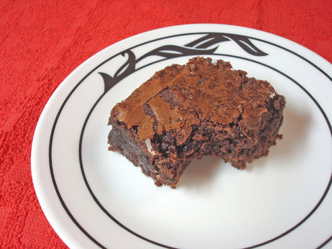 Brownie on a white plate set on a red placemat