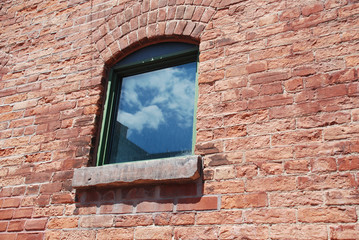Window to freedom on red brick wall
