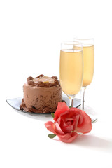 German chocolate cake, wine and a rose on white