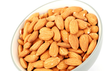 A bowl of shelled almond nuts on a white background.