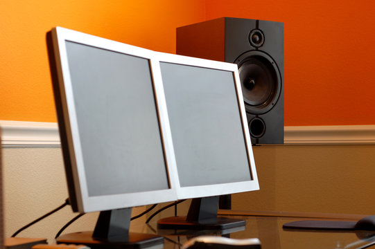 Dual Screen Computer Monitors And A Studio Monitor Speaker.