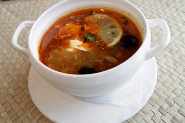 Russian solyanka - spicy soup of vegetables and meat with lemon
