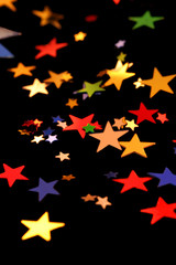 Multi-colored stars, scattered on black background.