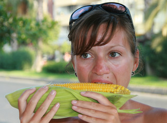 Young women eating messy corn on the cob