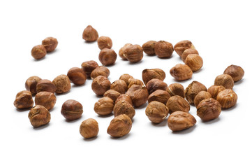 Hazelnuts spilled onto a white background