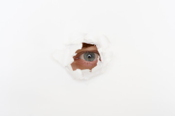 eye in the hole of white paper