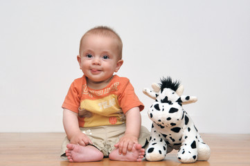 bébé assis avec sa peluche