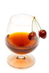 Glass of wine and cherries isolated on white