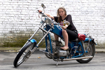 Plakat The beautiful woman sits on a motorcycle