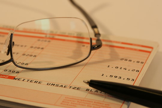 Kontoauszug, Stift und Brille