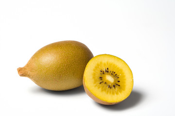 Fototapeta premium ganze und halbe goldene kiwi auf weissem hintergrund