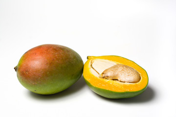 ganze und halbe mango isoliert auf weissem hintergrund