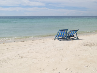 Two lawn chairs on a deserted beach