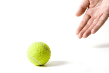 Hand releasing a tennis ball. Isolated on white background
