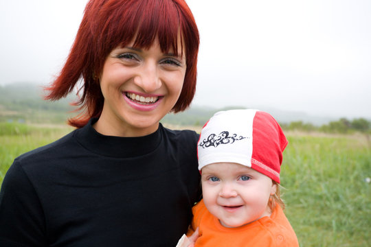 Young mom and the small daughter on the nature. 