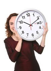 A pretty business woman hiding behind a clock