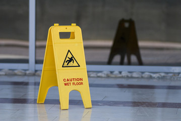 Yellow wet floor sign on marble floor