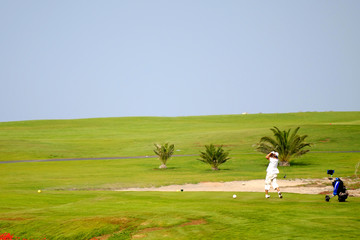 Naklejka na ściany i meble Man playing golf at exotic course